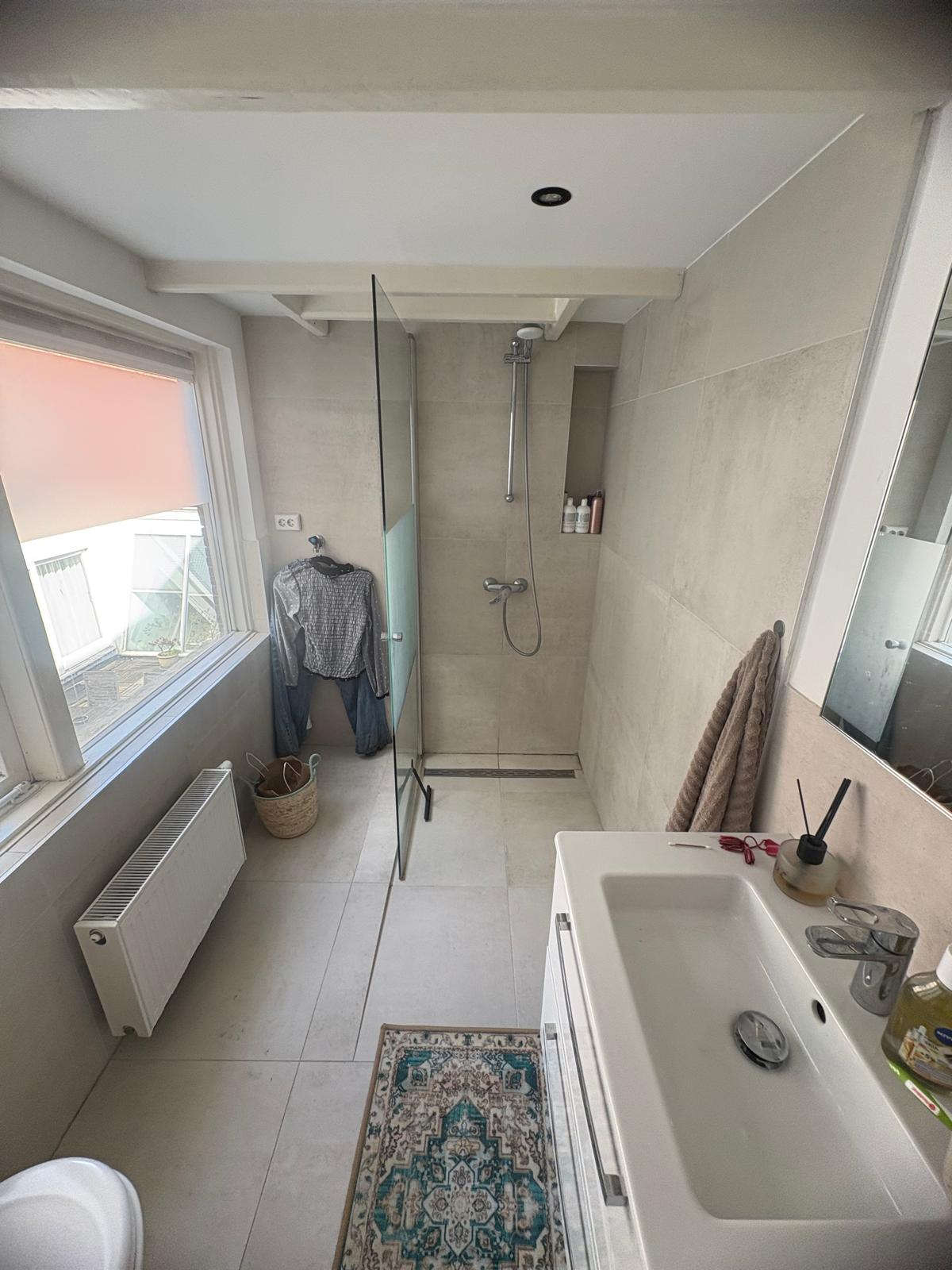 Modern bathroom with glass shower and light tiles