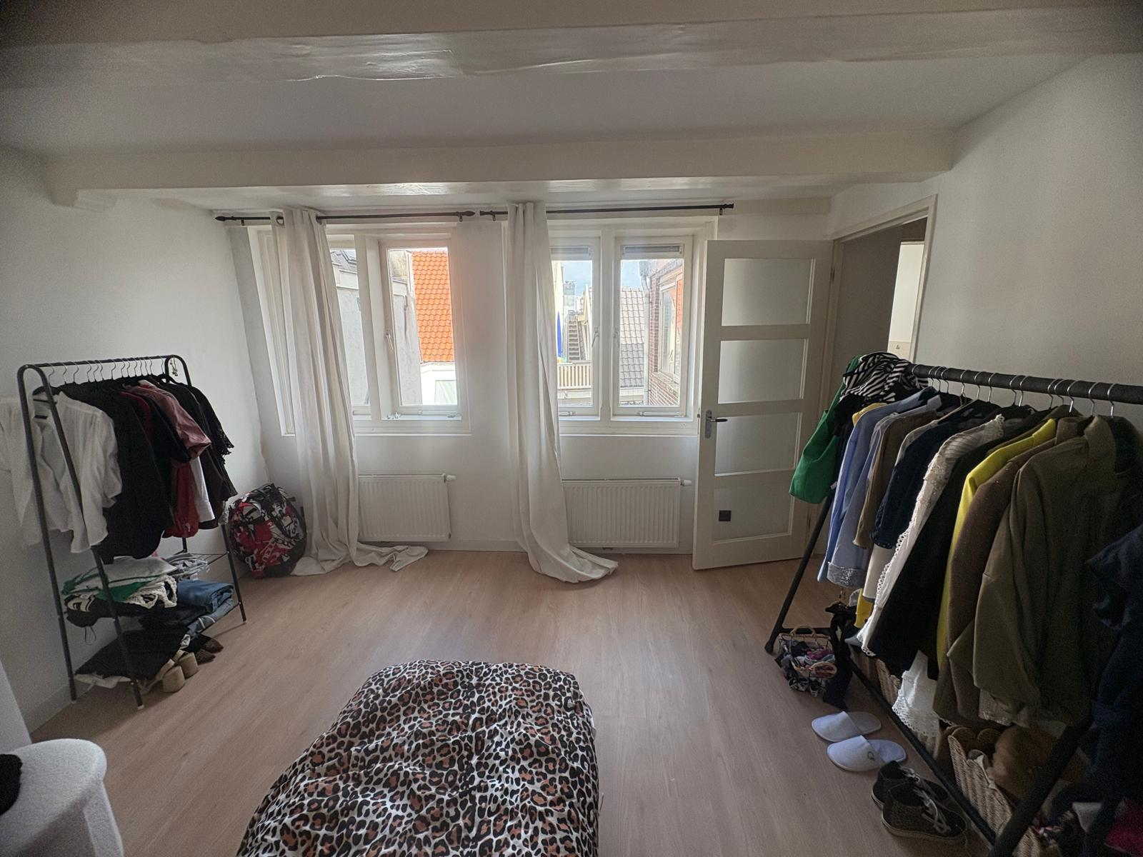 Spacious bedroom with large windows and city views