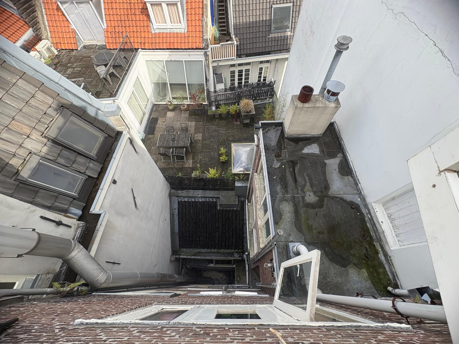 Aerial view of private terrace with patio furniture and Amsterdam rooftops